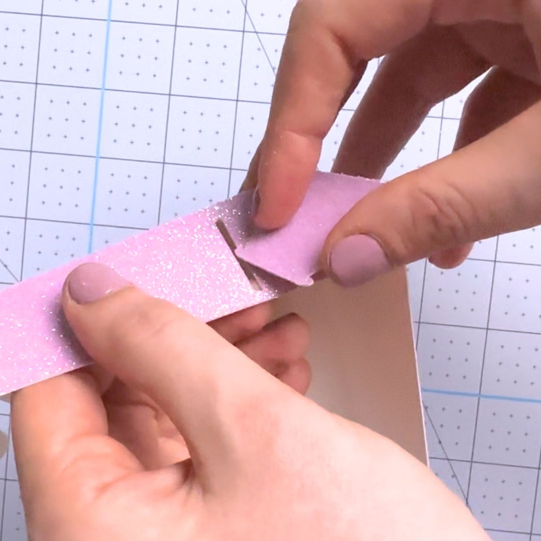 a person cutting a piece of paper with scissors