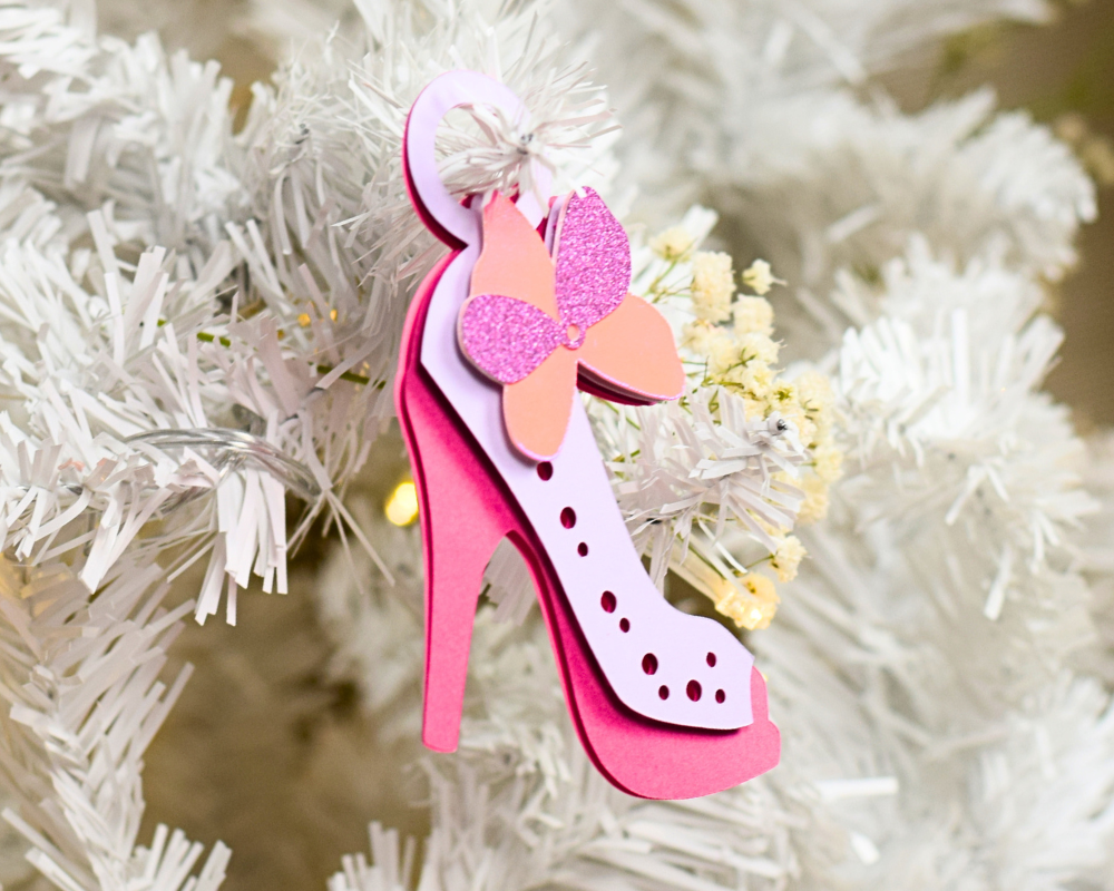 a pink shoe ornament hanging from a white christmas tree