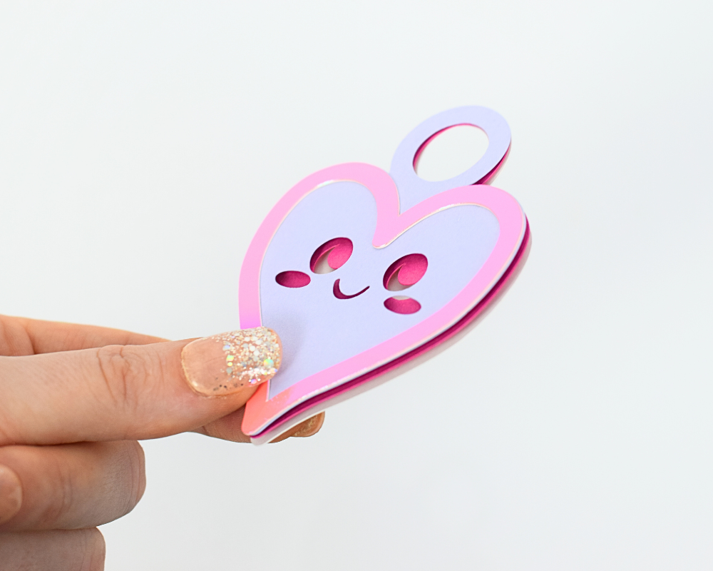 a hand holding a paper cut out of a heart