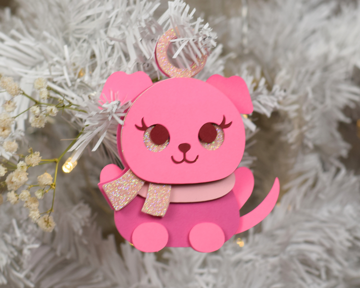 a pink ornament hanging from a christmas tree