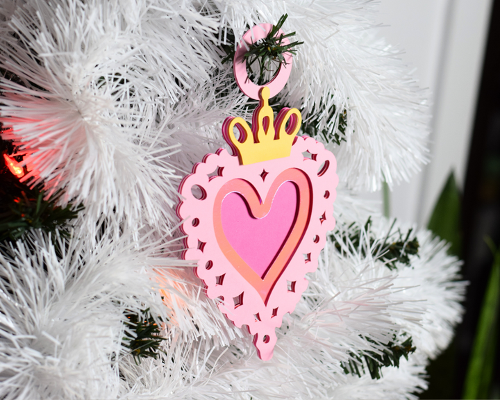 a pink ornament hanging from a white christmas tree