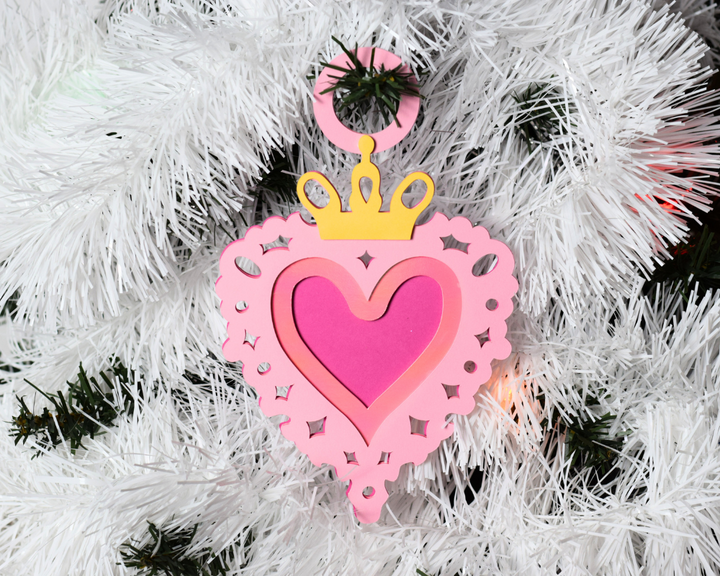 a pink ornament hanging from a white christmas tree