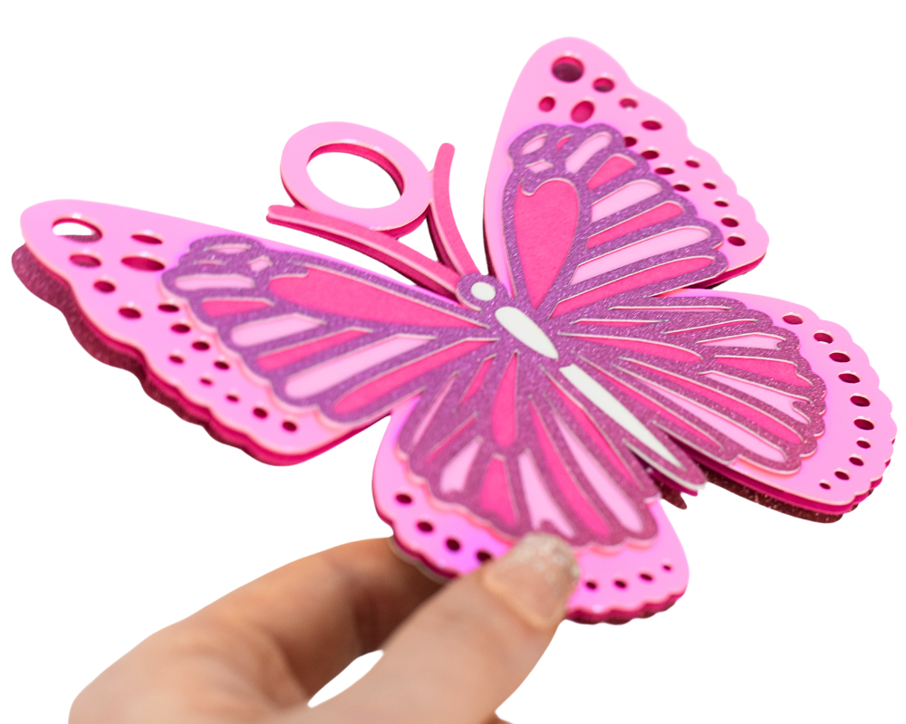 a hand holding a pink paper cut out of a butterfly