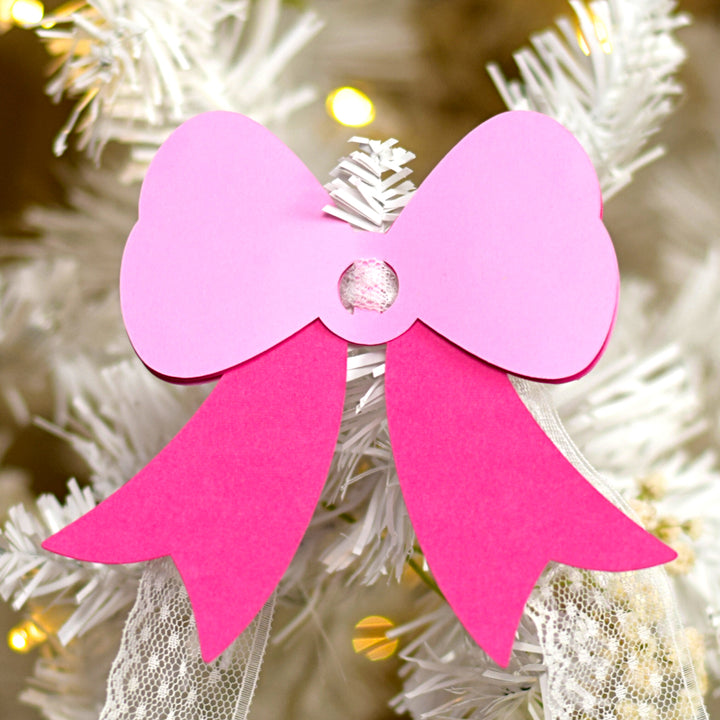 a close up of a christmas tree with a pink bow