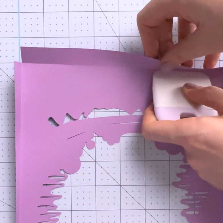 a person cutting out a piece of paper